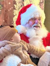 Grant Gornall, 6 months, of Newton looks up at Santa at the Wallisch Homestead on Sunday, Dec. 1. (Photos by Denise von Wilke)