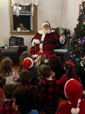 Santa reads holiday stories to children at the Lindy’s Lake Manor House on Sunday evening, Dec. 10. (Photo provided)