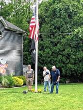 Veterans Mike Dunlap, John McClellan and Joe Zaccaro observe Memorial Day at the Birch Hills community. Zaccaro, who served in the Navy, led a ceremony, which included a moment of silent reflection and a patriotic song before the raising of the flag. (Photo provided)