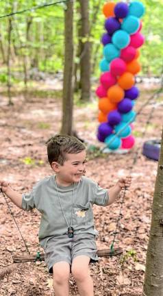 A child in the Sensory Garden and Play program plays on a swing hung between two trees during family day in June at Camp Wyanokie in West Milford. (Photos provided)