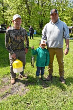 Geoffrey Toye III shows off his catch with his grandfather Brad, left, and father, Geoffrey II.