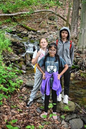 Three hikers stop for a breather by a stream on the West Milford trail.