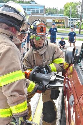 Firefighters use tools to dismantle a vehicle.