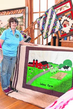 QT4 Linda Pierson of Franklin, vice president of the West Milford Heritage Quilters, stands by a quilt depicting a farm.