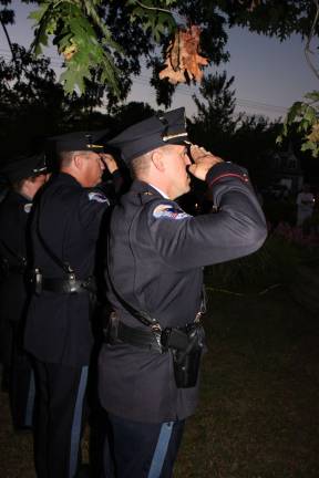 West Milford Chief of Police Timothy Storbeck salutes along with his officers at the township's 9/11 ceremony Tuesday night.