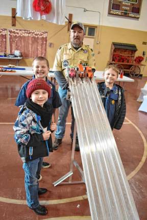 PD2 Pack 159 Cubmaster Bob Becker with a trio of Cub Scouts at the top of the racetrack. (Photos by Rich Adamonis)