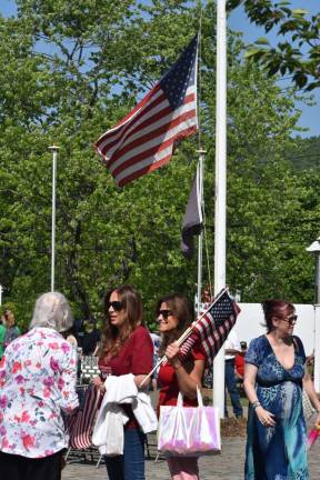 Volunteers hand out American flags before the ceremony.