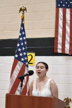 Gillian Rasp leads the singing of the National Anthem.