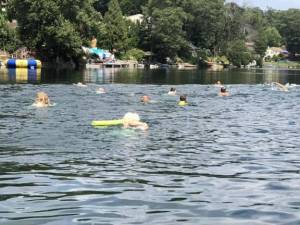 Participants begin a 580-meter swim leaving from and returning to the Lindy’s Lake beach Aug. 6, 2023. (File photo)