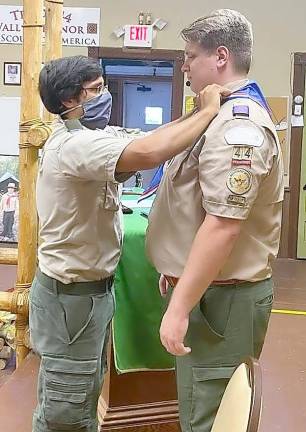 Former Scoutmaster of Troop 44 B (boy program) William Cytowicz awards Eric Lippe an Eagle Scout neckerchief.