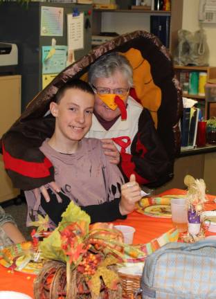 Jonathan of West Milford is being greeted by the Thanksgiving turkey, aka Principal Donna Furrey.