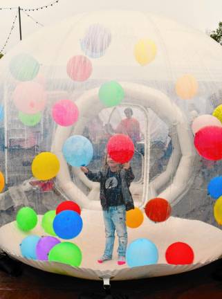 Fiona Crosser of Rockaway plays with balloons inside an inflatable Sunday, Sept. 29 at the Autumn Lights Festival in West Milford. (Photo by Maria Kovic)