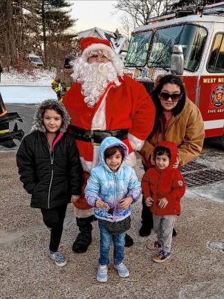 Santa poses with Heather Romanowski and her children, Ava, 8; Gabriella, 3 1/2; and Aiden, 3, in Hewitt. (Photo by Denise von Wilke)