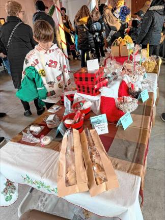 A boy looks at hand-crafted items for sale at the Christmas Market. Attendees also brought toys for the Highlands Family Success Center to distribute.