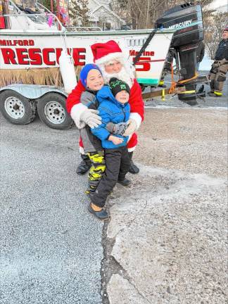 Santa hugs Dustin Becker and Jameson Kearns, both 7, on Sunday afternoon, Dec. 22. He was escorted by members of Upper Greenwood Lake Fire Company 5. (Photo by Denise von Wilke)