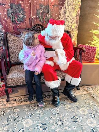 Giada Van Dyk, 7, of West Milford talks to Santa. The homestead’s first Christmas Market on Dec. 1 raises funds for its restoration.