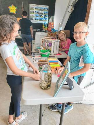 BB1 Bentley Batson, a third-grader at Marshall Hill School, shows residents how to make origami book marks at the recent book sale sponsored by the Friends of the West Milford Township Library at the Wallisch Homestead. (Photos provided)