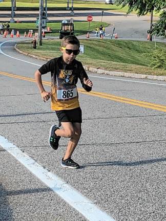 A. Fulton, 9, of West Milford runs up a hill toward the finish.