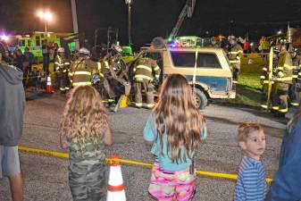 Residents watch a demonstration by firefighters using the ‘Jaws of Life’ to free a trapped motorist during the National Night Out event Tuesday, Oct. 1 at West Milford High School. (Photo by Fred Ashplant)