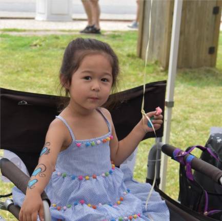 Hazel Sigman shows off her arm tattoo while holding a helium-filled balloon.