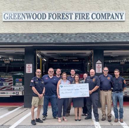 Rehab Elmoslemany and Karen Sabyan of Lakeland Bank present a $3,000 check to members of Greenwood Forest Fire Company in West Milford. (Photo provided)