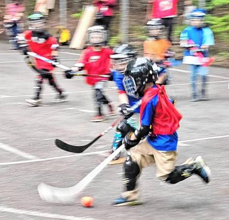 Children play street hockey on the asphalt basketball courts at Westbrook Park in West Milford. (Photos by Rich Adamonis)
