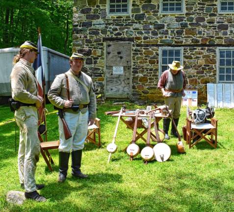 A couple of Confederate soldiers look at a selection of banjos, which were popular music intruments of the period.