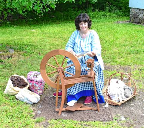 Linda Pierson demonstrates spinning sheep’s wool that would be used to create coats, hats and other uniform pieces.