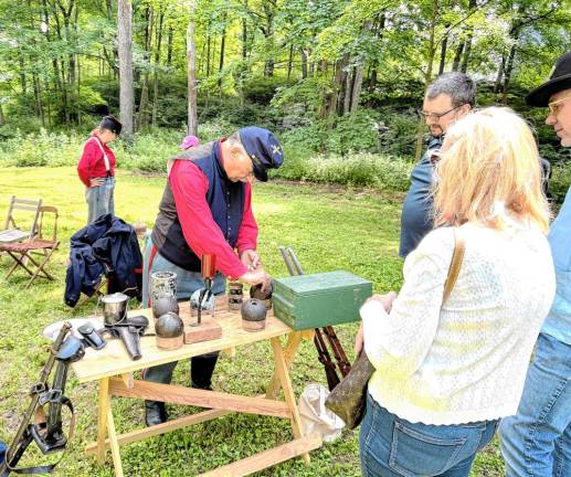 Cmdr. Sgt. Jeffery Cohen tells visitors how the artillery shells were used.