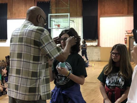 Optician Floyd Patterson helps fit new glasses on a camper.