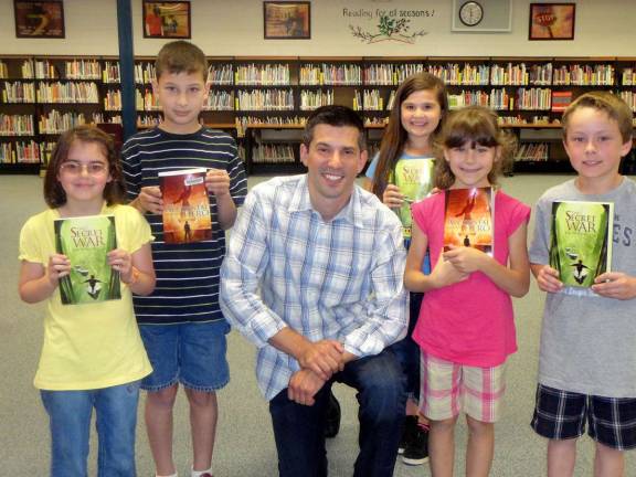 Westbrook students April, Derek, Nicolette, Kathryn and Collin were eager to get and read the books written by author Matt Myklusch, who visited the school last month.