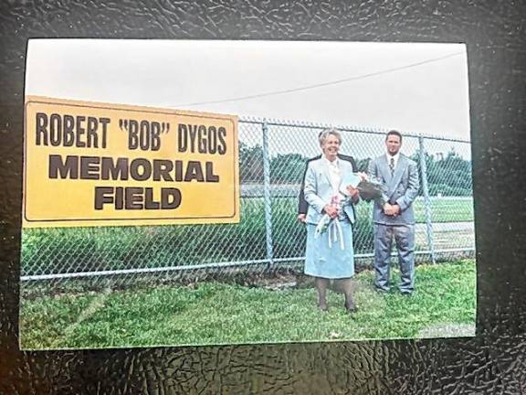 Christel Dygos celebrates the opening of Robert ‘Bob’ Dygos Memorial Field in 1995. Their son Richard is at right and their son Ron is behind his mother.