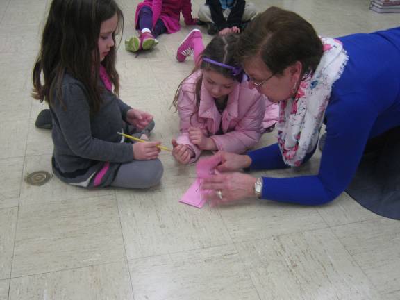 Teacher Cheryl Bradon works with students to complete a math relay.