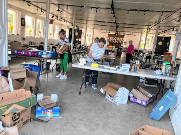 Members of the Friends of the West Milford Township Library sort donated books in the barn.