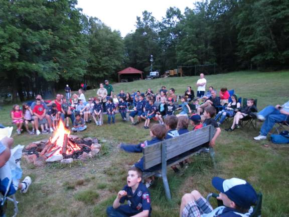 Cub Scouts and their families gather around the bonfire.