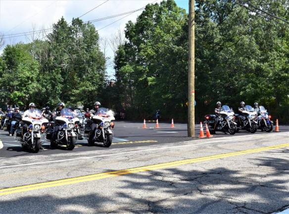 Police officers lead the riders.