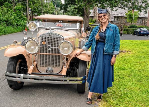 Hillary Ryan Goldman, a Realtor with Howard Hanna Rand Realty in Goshen, N.Y., poses with an old car.