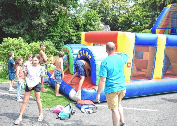 Children gather at the entrance to the bounce house.