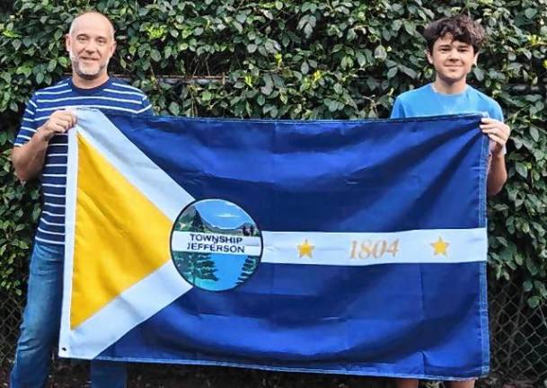 Jack Murphy and his father, John, hold the flag he designed for Jefferson Township.