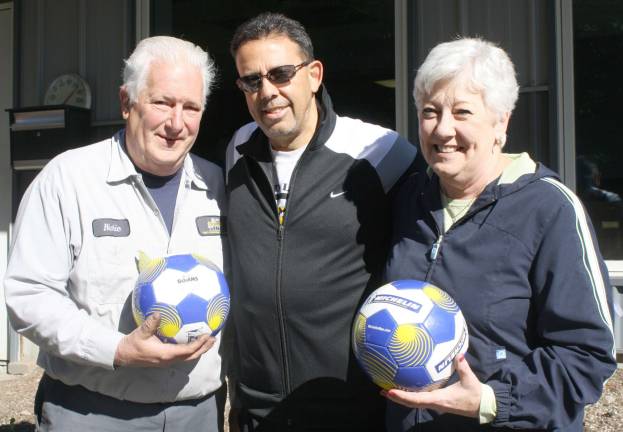 Photo by Linda Smith Hancharick Richie Gomm, left, and Cookie Gomm, right, donated 450 soccer balls to the Police Athletic League. Mark Minadeo, center, a PAL board member, called the donation &quot;tremendous.&quot;&lt;saxo:ch value=&quot;226 128 168&quot;/&gt;