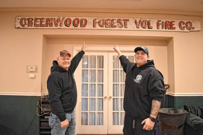 President and former chief Mike Spoelstra, left, and Chief Keith Weber show the once outdoor Greenwood Forest Volunteer Fire Company sign. (Photo by Rich Adamonis)