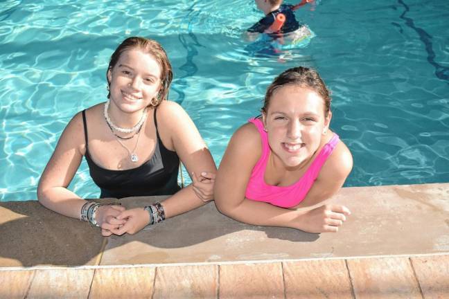 Volunteer Allie Rockey, left, with camper Julia de Grandpré in the Shiloh Bible Camp indoor pool. (Photo by Rich Adamonis)