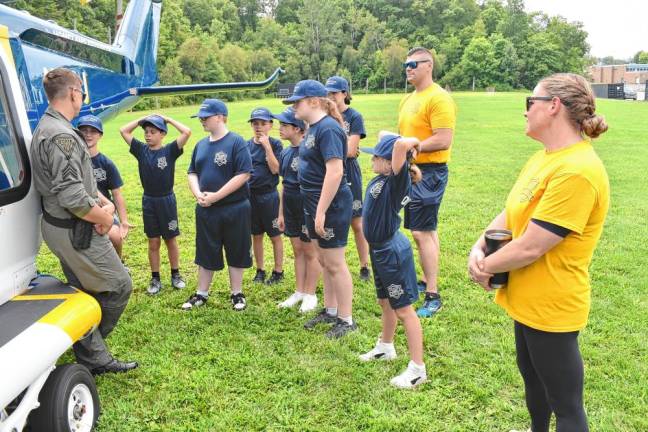 Cadets learn about helicopter operations. With them are Junior Police Academy instructors Juvenile Detective Derek Finley, center, and Officer Amy Antonucci.