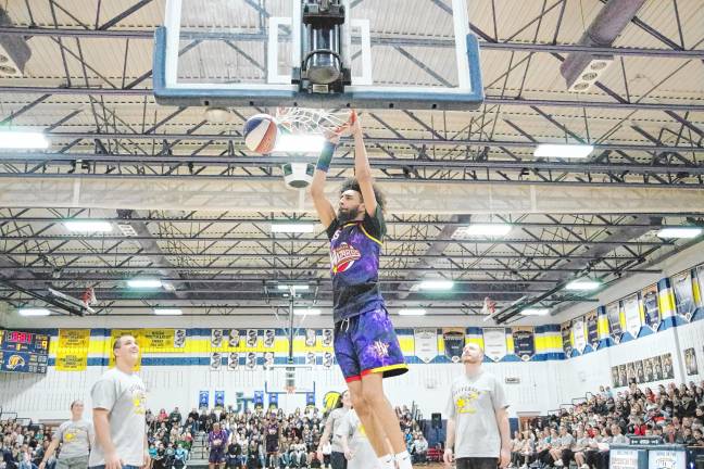 Harlem Wizards player Tyler ‘Sky-Rise’ Cronk dazzles the opposing team and the crowd while performing a dunk.