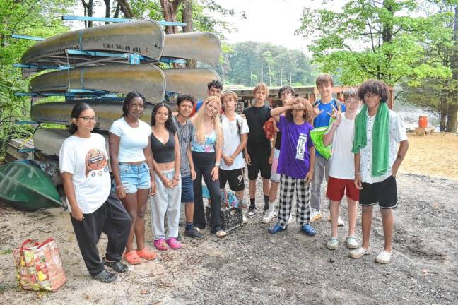 Sylvie Phillips, fifth from left, a first-year teen leader from London, with teenage campers. ’The vibe, outdoors and people are all great. I love it and am proud to be here on its 100th anniversary!’ she says. (Photo by Rich Adamonis)