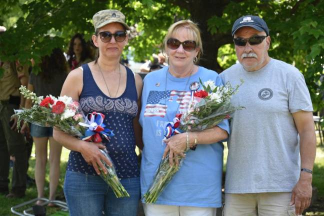 WMP3 From left are Tonya Butkus and Shirley and Nino Parrello, who were presented with flower bouquets during the Memorial Day ceremony. Butkus’s brother Jason and the Parrellos’ son Brian were killed in Operation Iraqi Freedom. They are standing in front of a memorial and tree planted in honor of Brian.