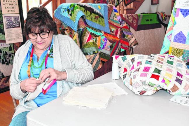 Debbie Van Brunt of West Milford shows how to make a cathedral window quilt Saturday, March 16 at the West Milford Museum. (Photo by Maria Kovic)