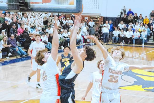 Jefferson's Nick Currie, center, jumps high during a shot in the first half. Currie scored 12 points.