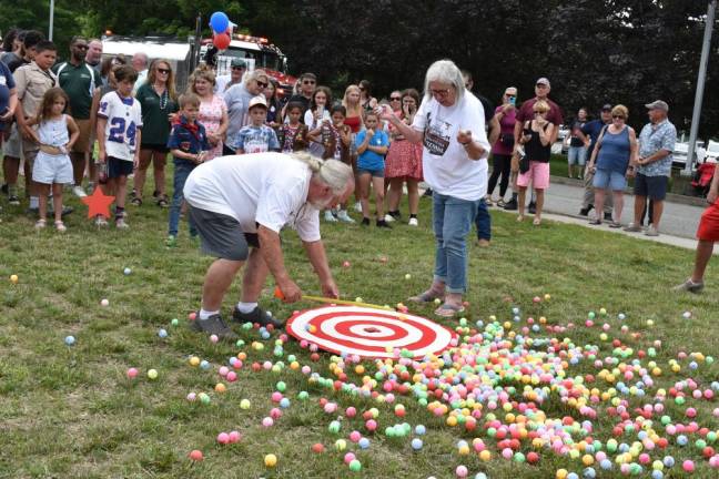 Officials measure to find out which numbered ball fell closest to the target. Standing center is Nancy Clifford, a trustee of Greenwood Lake, N.Y. (Photo by Rich Adamonis)