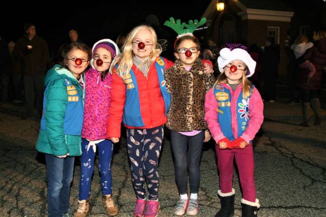 Local Girl Scouts don red noses and prepare to join along singing Rudolph the Red Nosed Reindeer with the crowd Monday night.